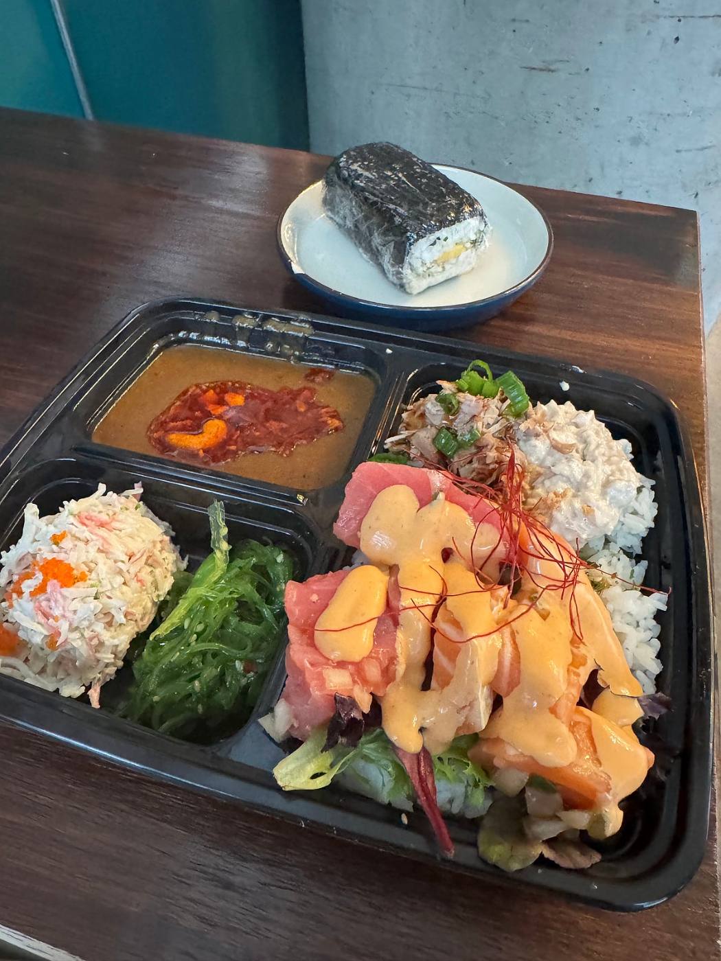Bento tray at Gyo Gyo En with chirashi, seaweed salad, crab salad and an onigiri on the side