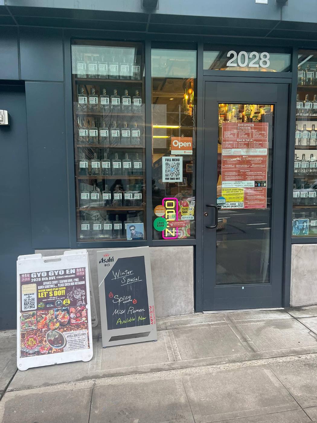 The Gyo Gyo En storefront at 2028 8th Ave in Seattle, with sidewalk menu boards and a window of bottles